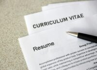 Top view of stack of office documents including resume and cv forms